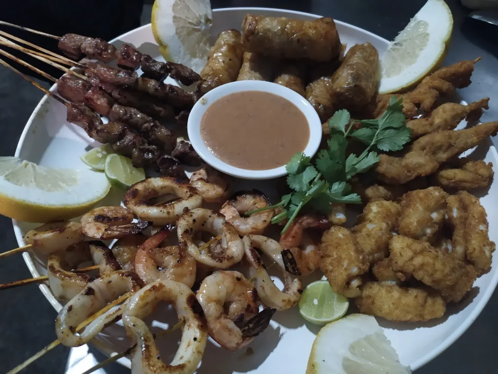 Grand plat de brochettes, nems et fritures avec sauce