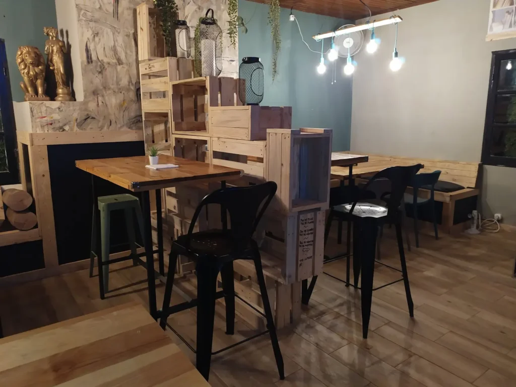 Salle avec tables hautes, tabourets et étagères en bois