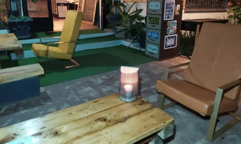 Terrasse avec fauteuils en cuir et bougie sur une table basse en bois